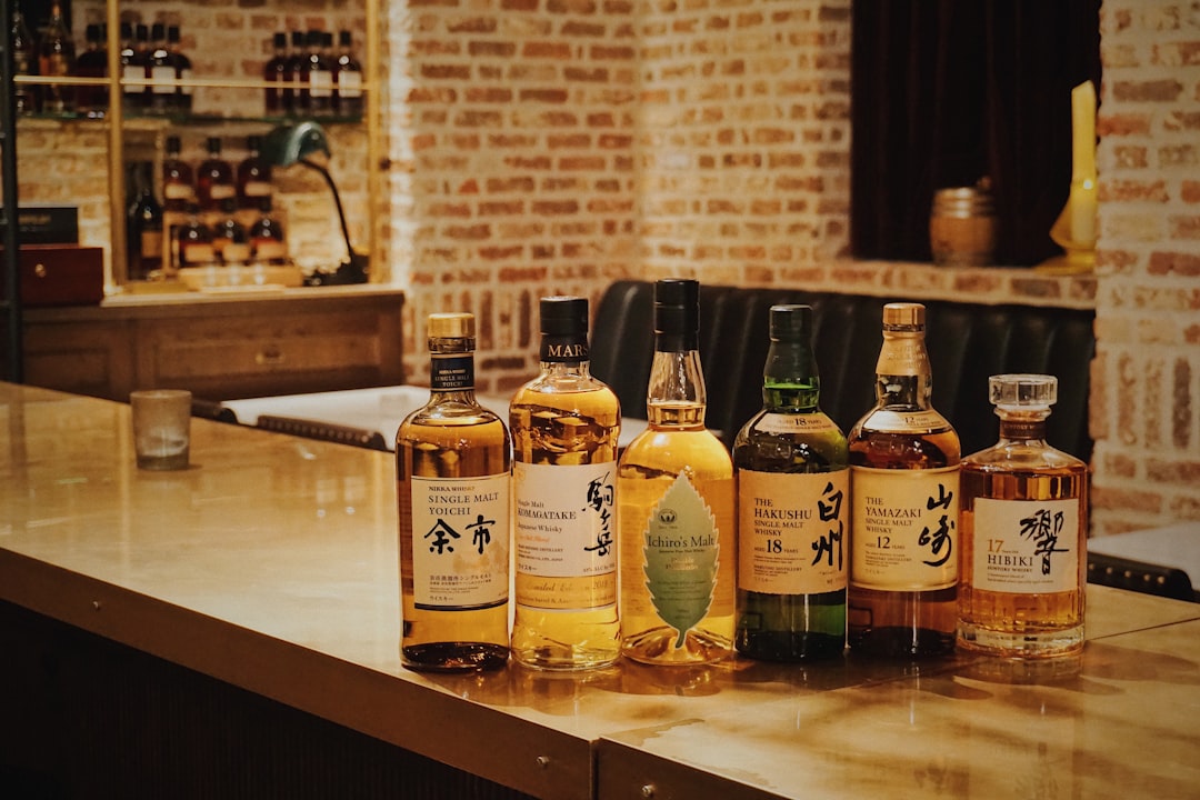 single malt whisky bottles lineup, whisky tasting glass amber