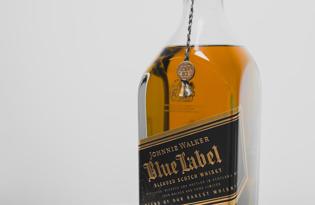 single malt whisky bottles lineup, golden whisky glass warm light